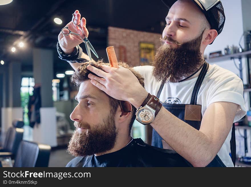 Dedicated hairstylist using scissors and comb