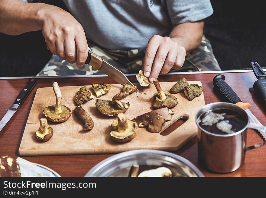 Hands cut raw mushrooms with sharp knife