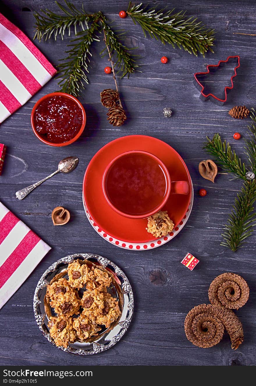 Raspberry tea, raspberry jam and homemade cookies on a dark wooden background. Top view