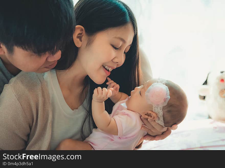 Closeup portrait of happy family with little baby on the bedroom