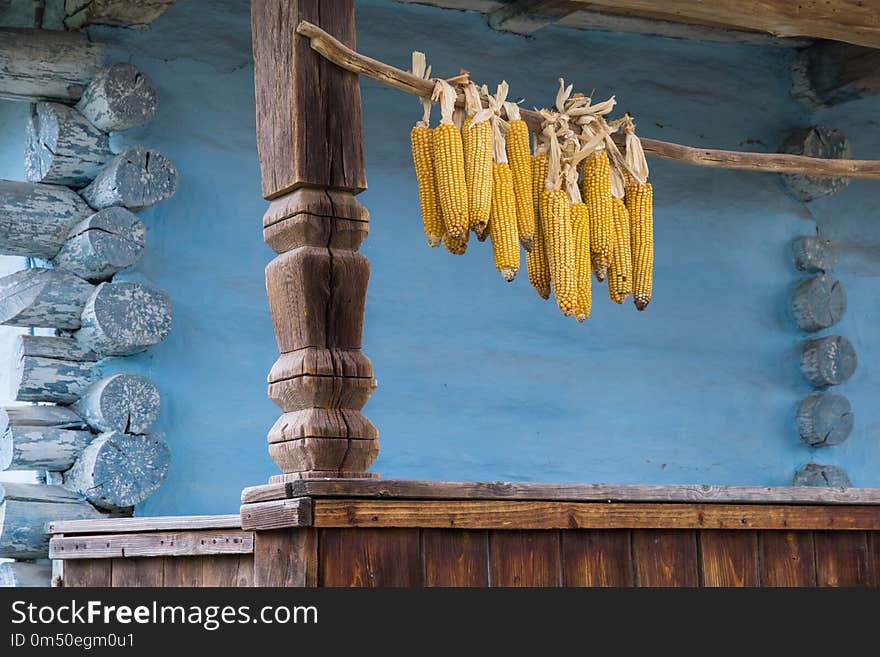 Wooden terrace in a rural national house with crocheted dried corn on the beam. Wooden terrace in a rural national house with crocheted dried corn on the beam