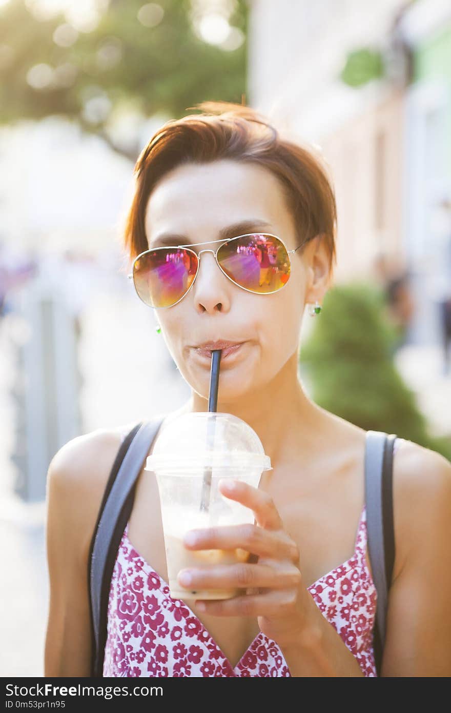 A girl drinks a drink through a straw.