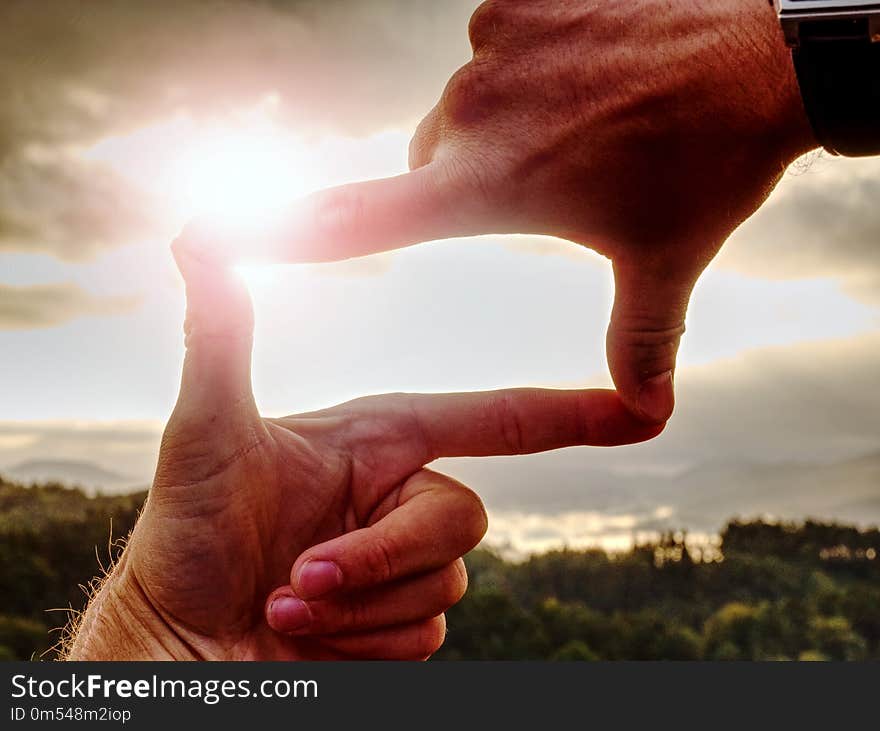 Palms with fingers making a frame sign over misty landscape