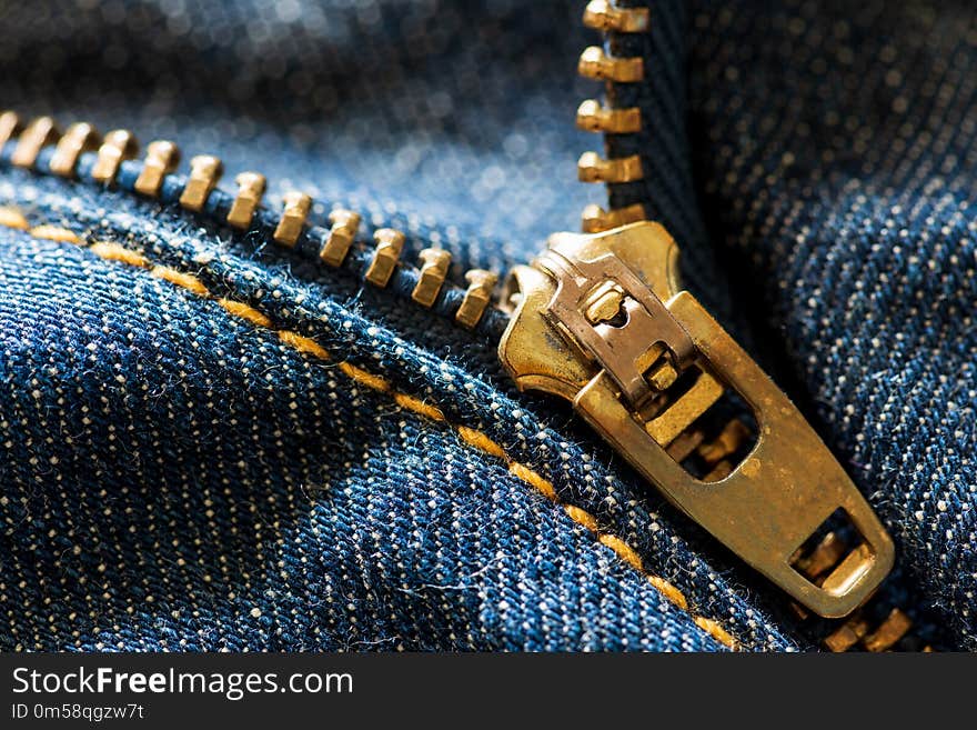 Close up and macro blue jeans zipper on blue jeans background. Close up and macro blue jeans zipper on blue jeans background.