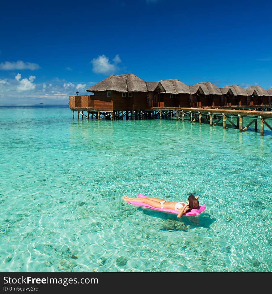 Woman swim and relax in the sea. Happy island lifestyle. White sand, crystal-blue sea of tropical beach. Vacation at Paradise. Ocean beach relax, travel to Maldives islands