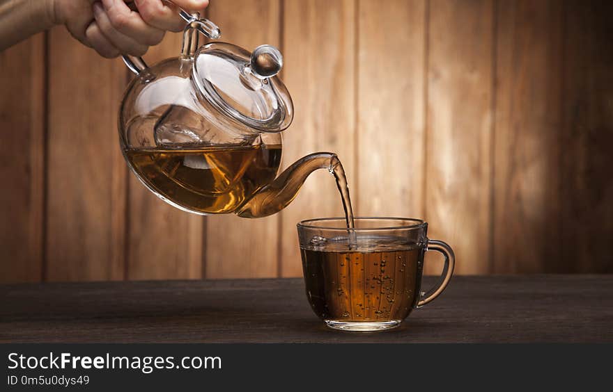 Poured from a teapot cup of tea on a wooden table