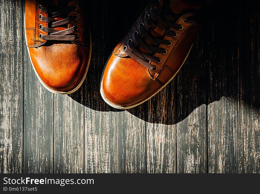 Brown leather shoes on wooden background top view with copy space