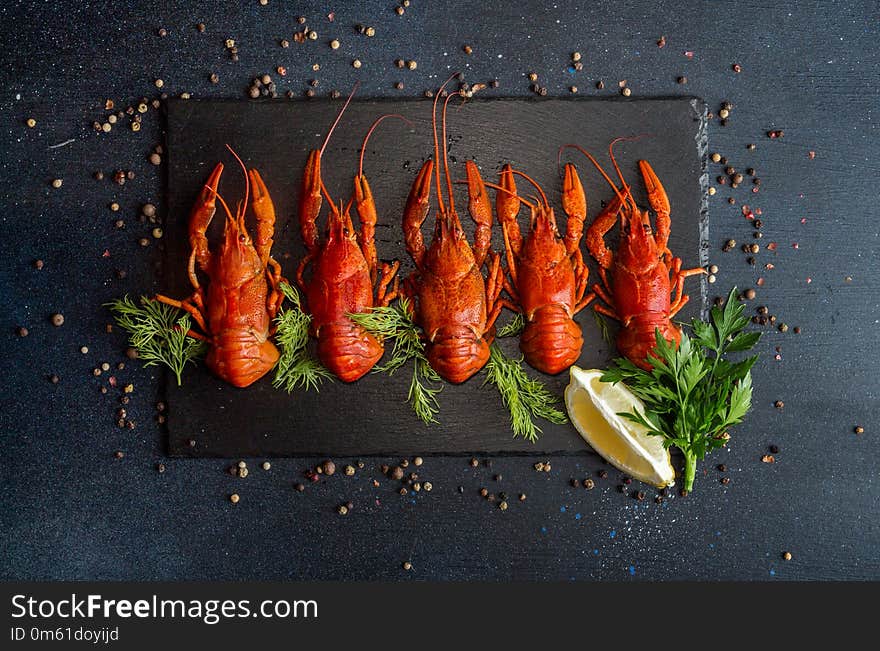 Boiled cooked crayfish crawfish ready to eat on black background. Copy space. Overhead.