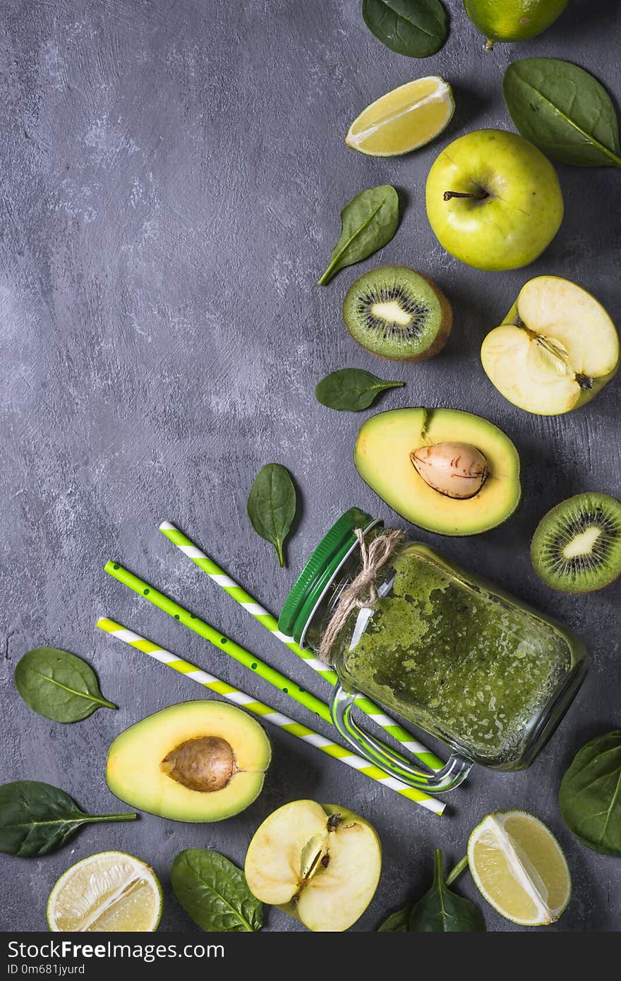 Healthy green smoothie in mason jar and ingredients. Superfoods, detox, diet, healthy food. Lime, apple, spinach, avocado and lime. Green food background