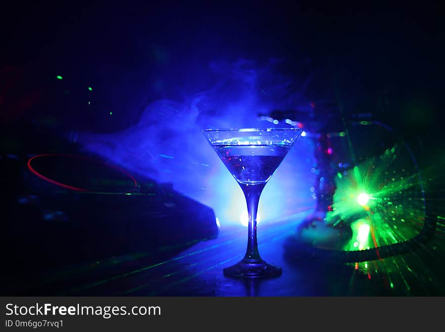 Glass with martini with olive inside on dj controller in night club. Dj Console with club drink at music party in nightclub with d