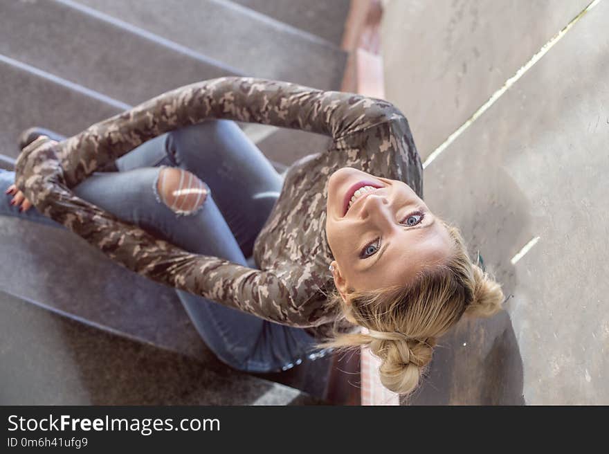 Blonde girl sitting on stairs