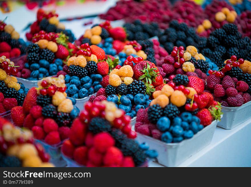 Fresh different berries in the plastic cup at Europe street berries and exotic fruits at market streetshop