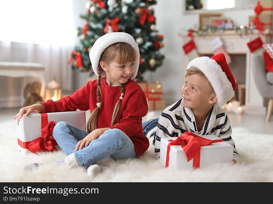 Cute Little Children In Santa Hats With Christmas Gift