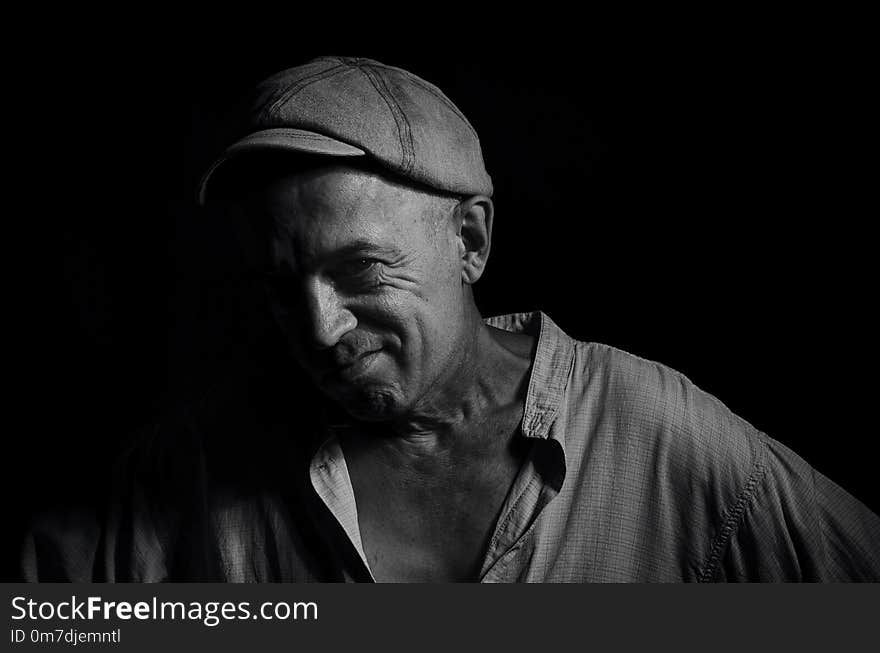 Portrait of an elderly man in a cap on a dark background . Portrait of an elderly man in a cap on a dark background .