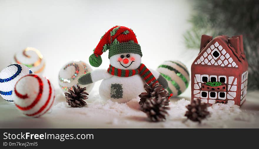 Toy snowman and a gingerbread house on a light background. photo with copy space.