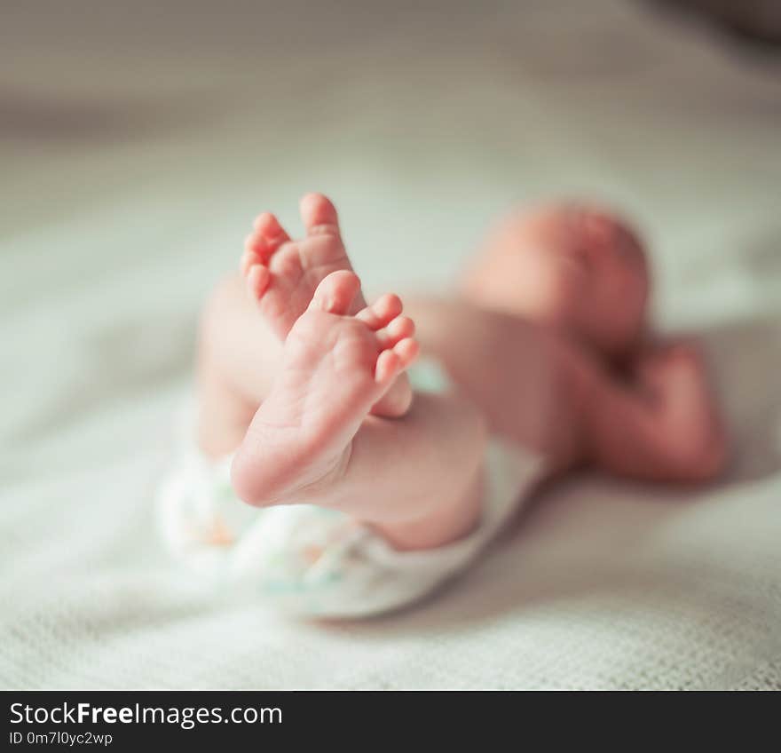 Health concept - closeup of legs of a newborn baby lying on white blanket.the photo has a empty space for your text