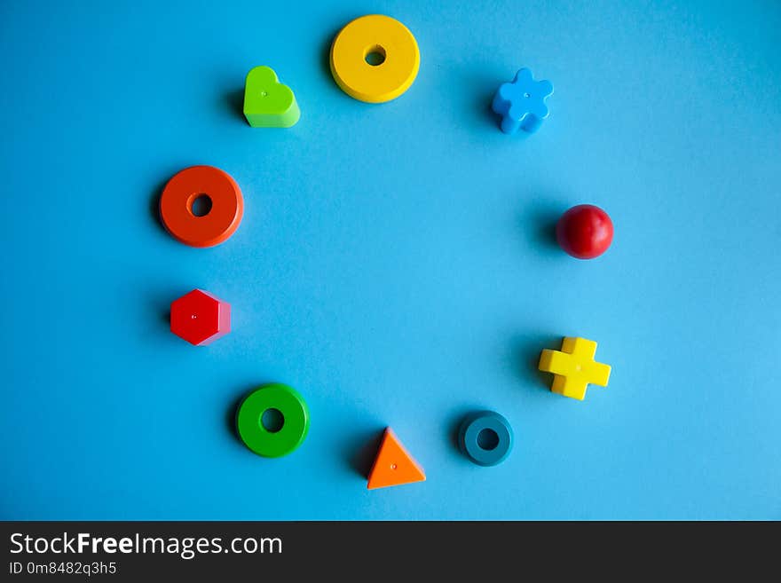 Child creativity art and handcraft. construction kits for fine motor skills development. colorful wooden pieces or plastic details in a circle on blue background. Child creativity art and handcraft. construction kits for fine motor skills development. colorful wooden pieces or plastic details in a circle on blue background.