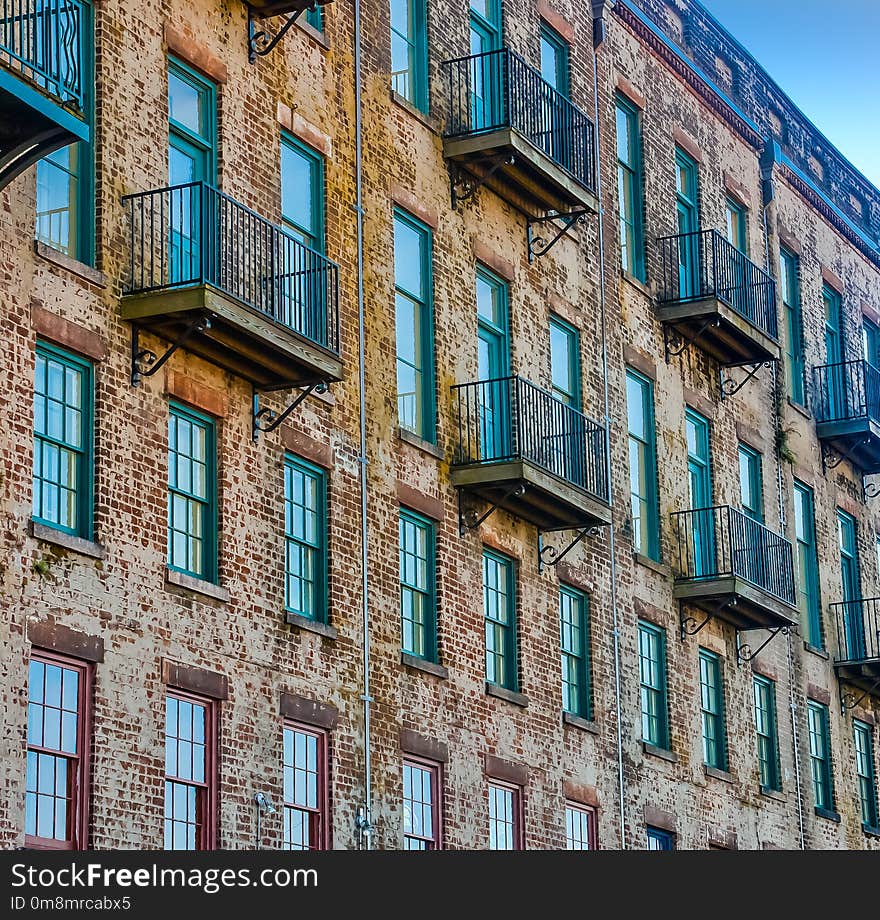 An old brick building with green iron windows and balconies. An old brick building with green iron windows and balconies