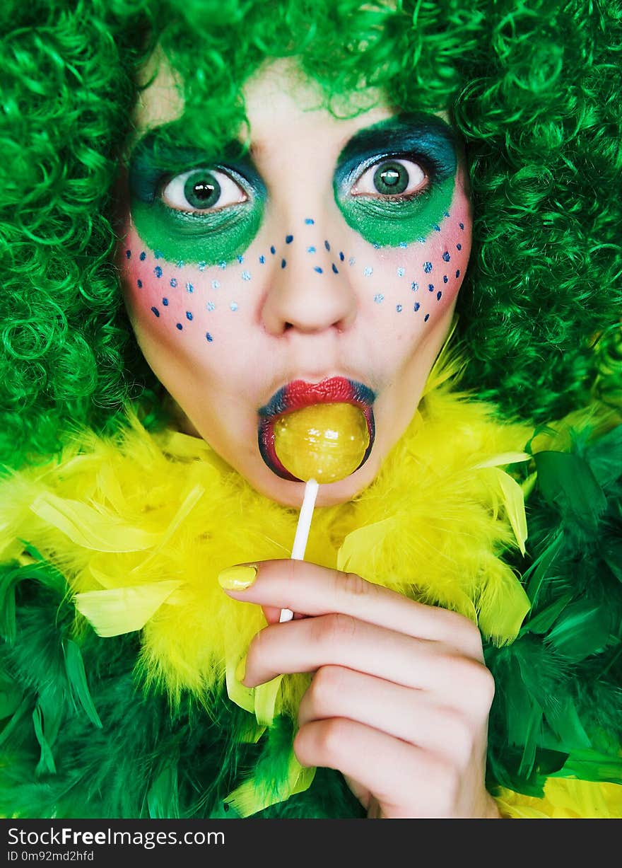 Close up of a face of a girl with creative visage with lollipopr