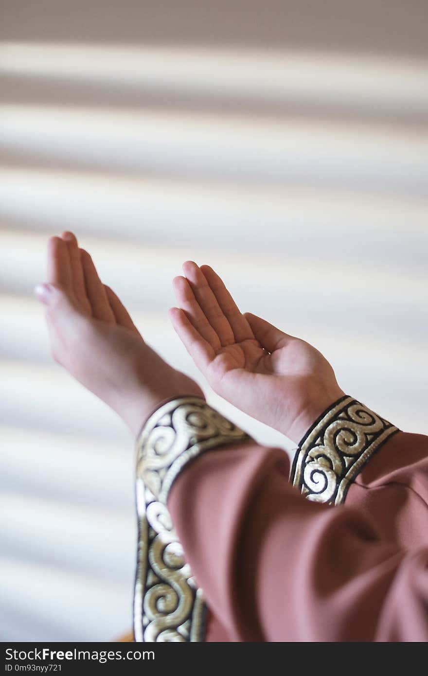 Hands of muslim people praying with mosque interior background.