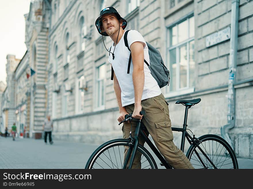 A man riding a bike in an old European city outdoors. Lifestyle, ecological transport, people concept.