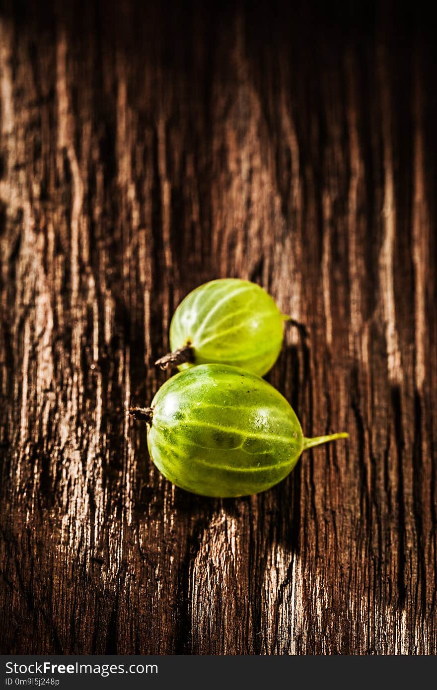 Ripe gooseberries on vintage wooden board