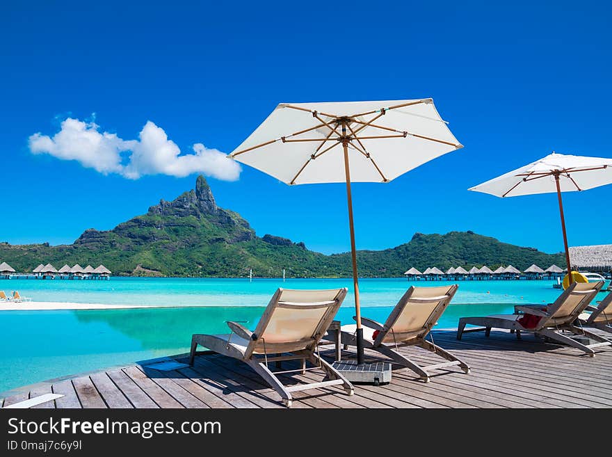 White cloud, blue sky, white umbrella and turquoise water in Bora Bora. White cloud, blue sky, white umbrella and turquoise water in Bora Bora.