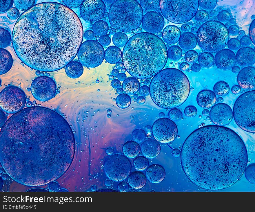 Macro of oil drops and pigment on water surface with bright background. Macro of oil drops and pigment on water surface with bright background