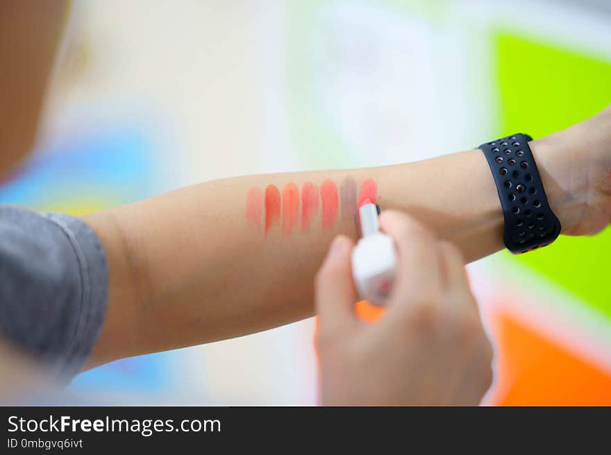 woman use lipsticks paint on arm for test colorful on blur background