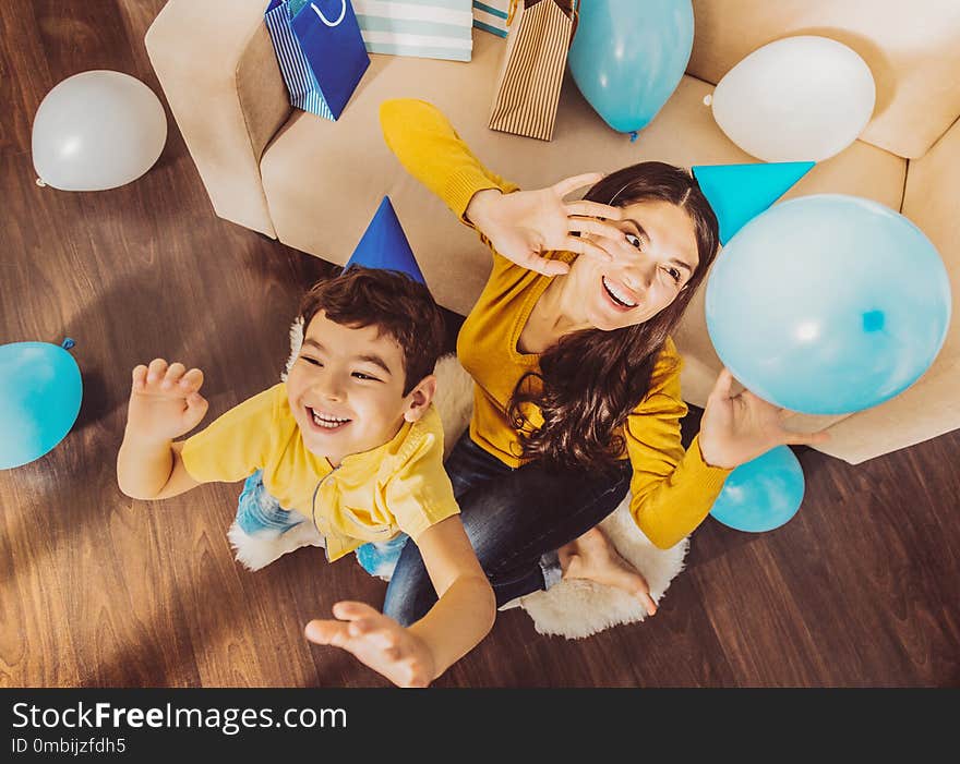 Cheerful happy woman and boy monkeying with balloons