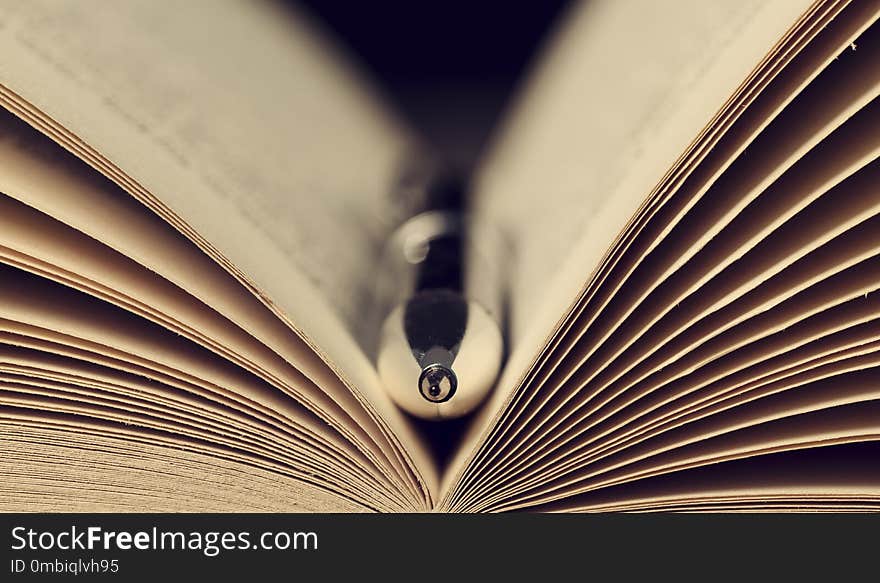 Close-up of a silver pen in the open pages of a book