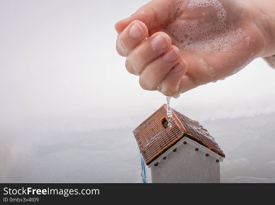 Model house in hand in foamy water