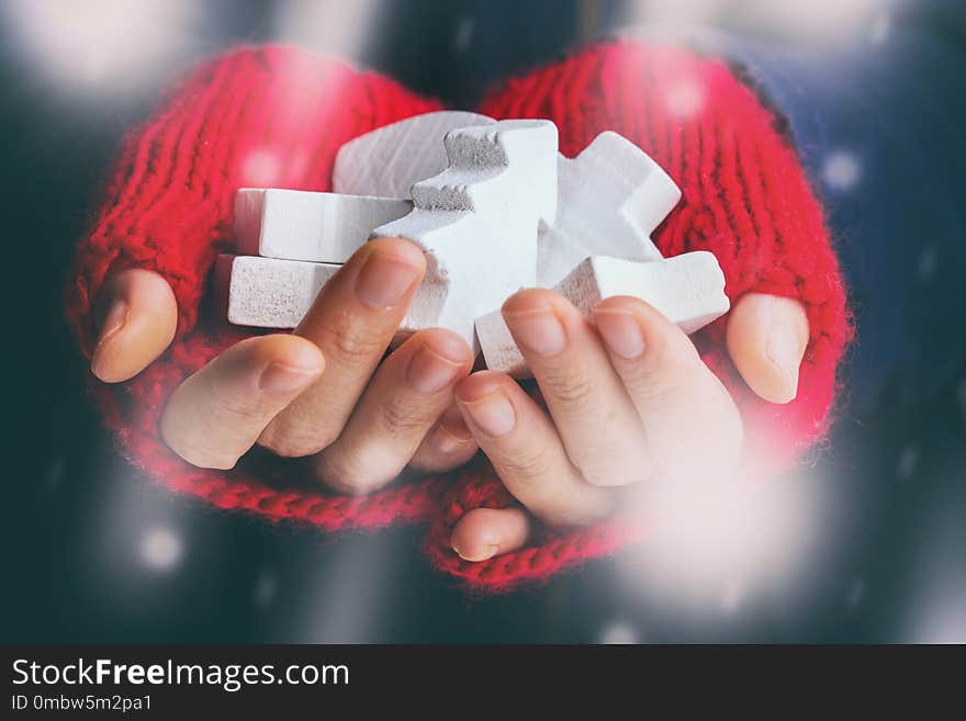 Christmas Background - female hands in red gloves hold a New Year`s toys. Christmas Background - female hands in red gloves hold a New Year`s toys