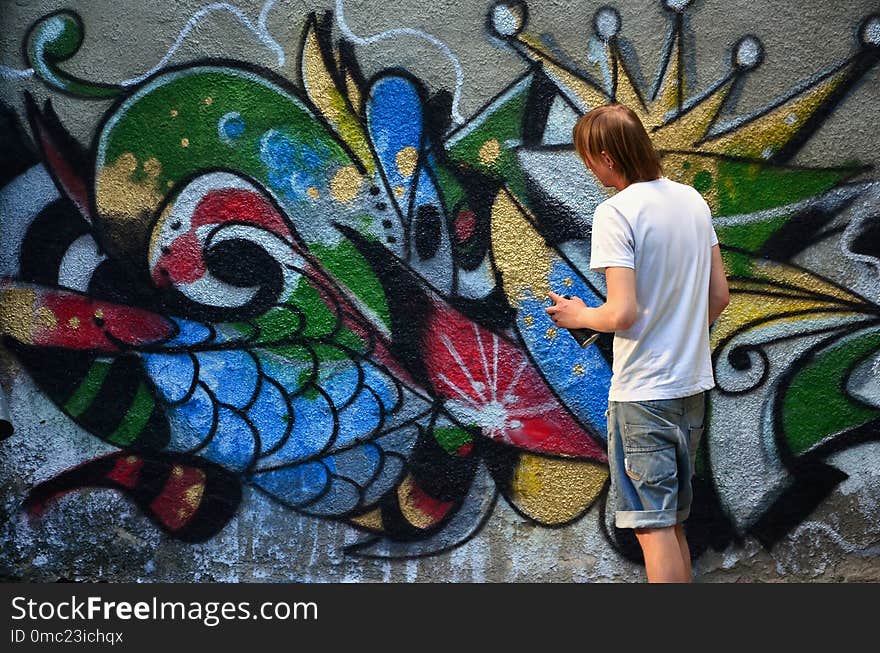 Photo of a young guy in denim shorts and a white shirt