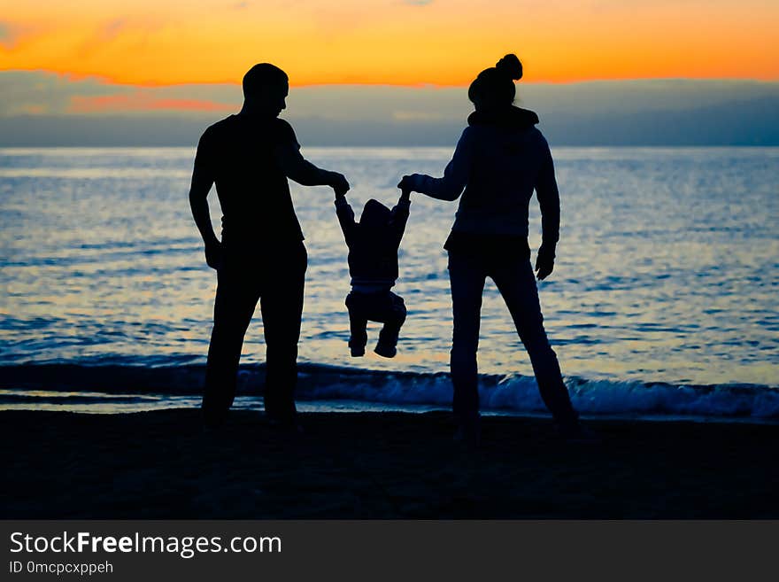 Happy family with baby on the beach at sunset. Happy family with baby on the beach at sunset