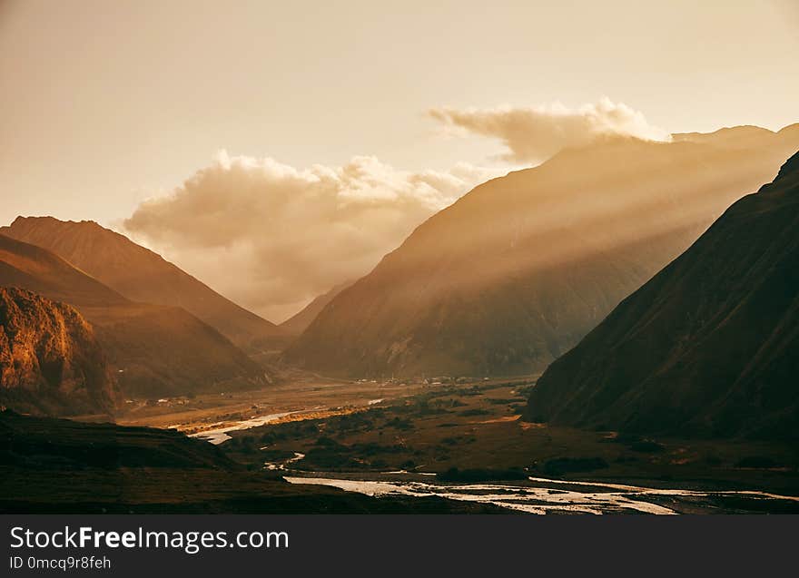 Sunset dawn in the mountains. Caucasian mountains. Mount Kazbek. The sun`s rays pass through the mountains. Sunset dawn in the mountains. Caucasian mountains. Mount Kazbek. The sun`s rays pass through the mountains