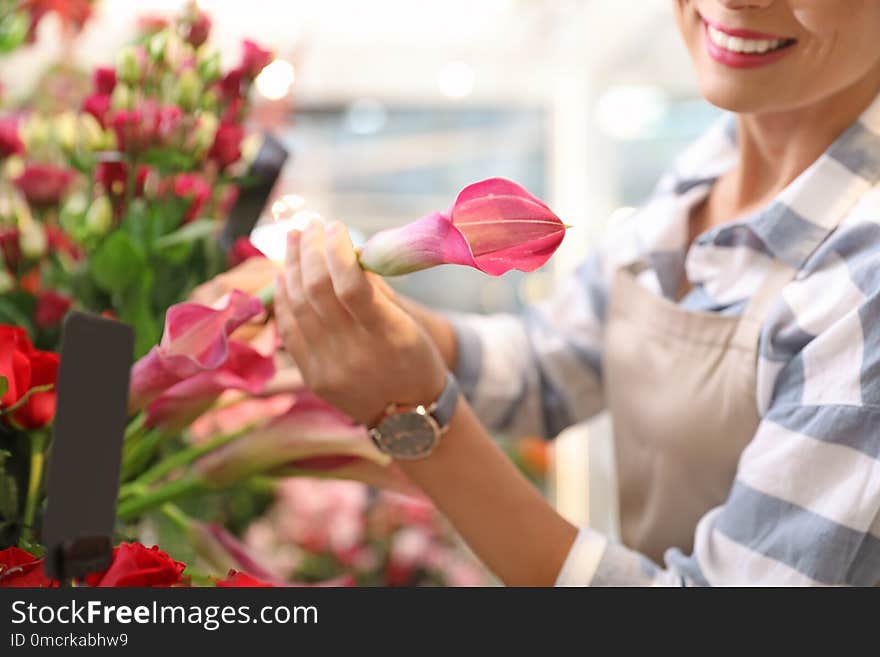 Female florist working in flower shop, closeup