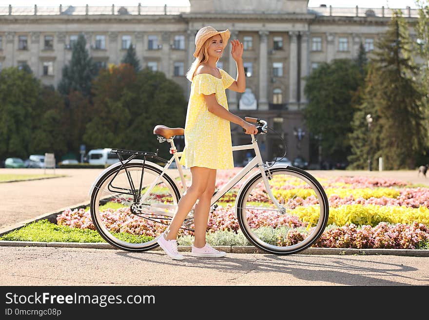 Beautiful happy woman with bicycle on street