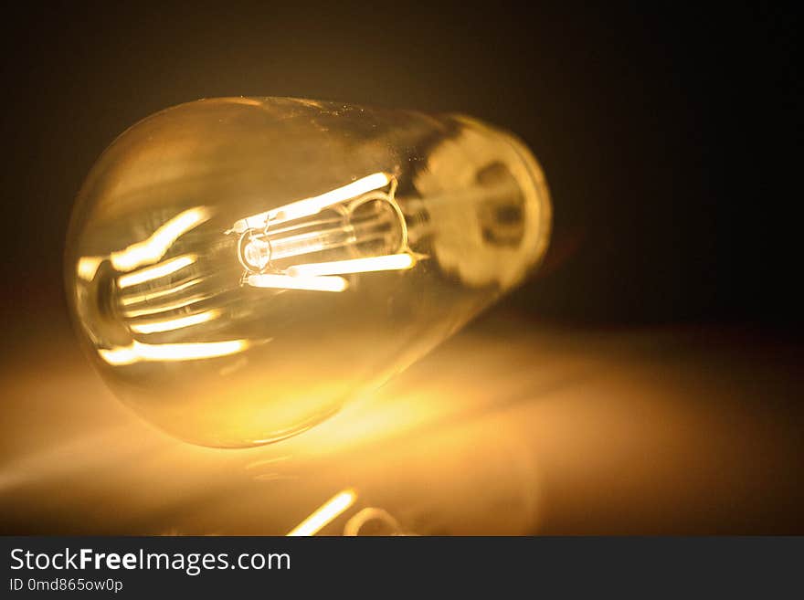 Close-up photo of light bulb on dark background.