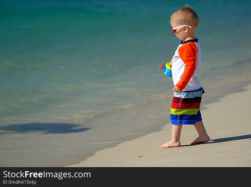 Two year old toddler playing on beach