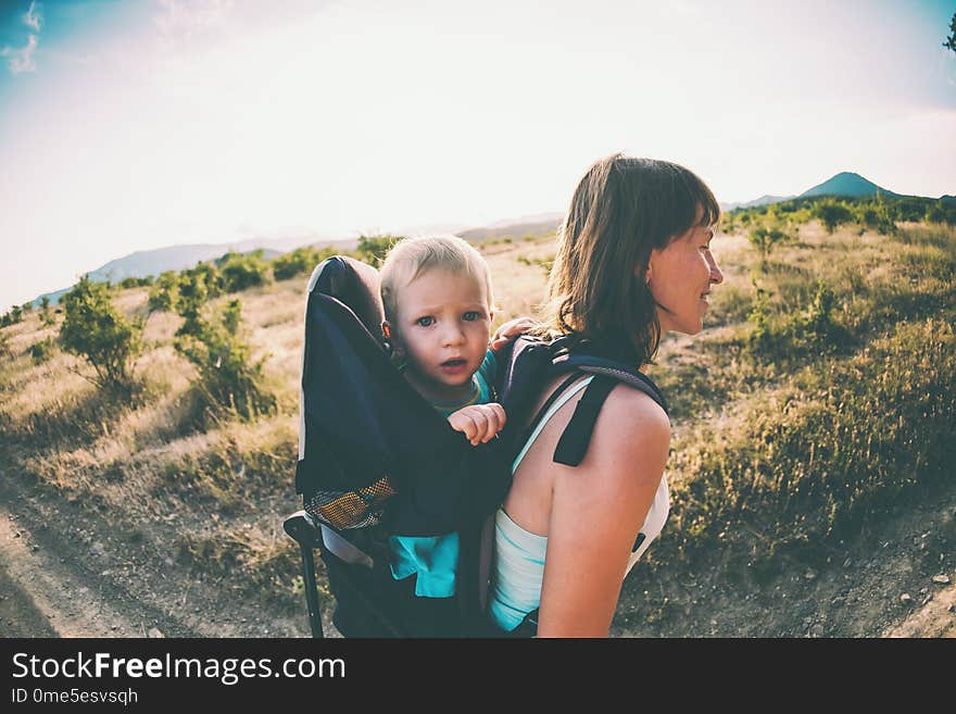 A woman is carrying a backpack with her baby.