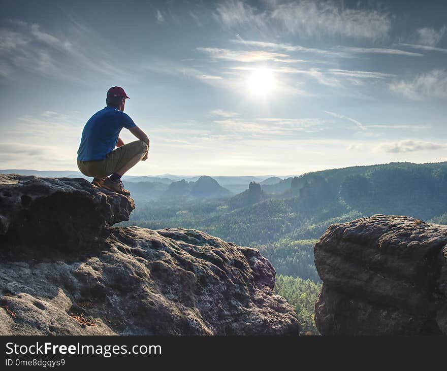 Hiker watching to Sun at horizon. Beautiful moment the miracle of nature. Colorful mist in valley. Man hike.