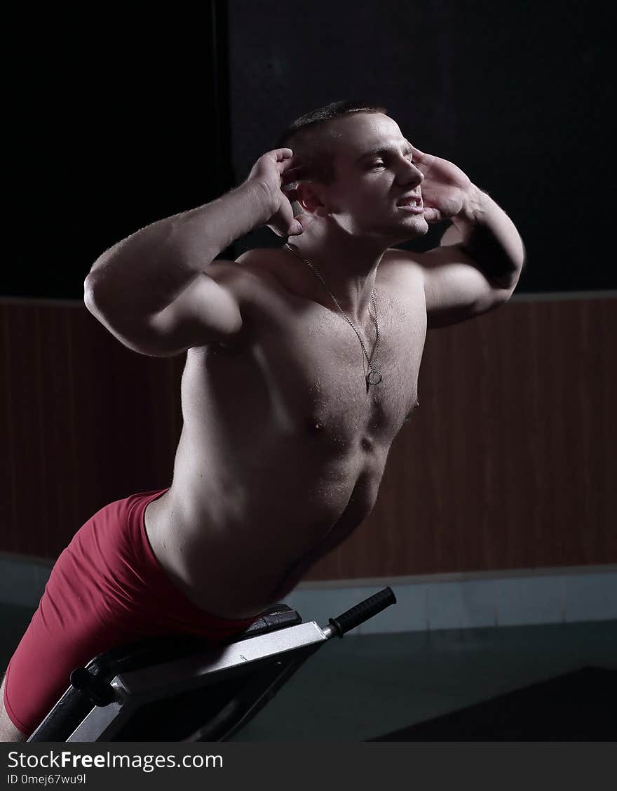 Young Handsome Man Performs Sport Exercises To Strengthen Muscles