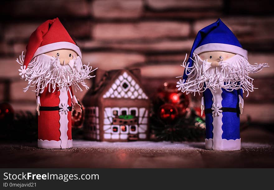 Two Funny Santa Claus On The Background Of A Gingerbread House.