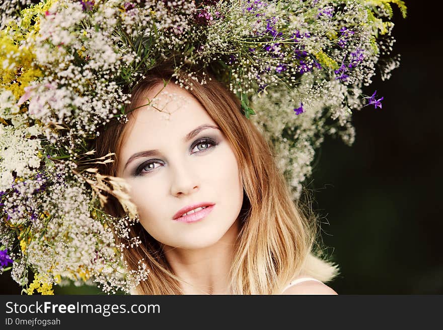 A girl in a wreath of field flowers