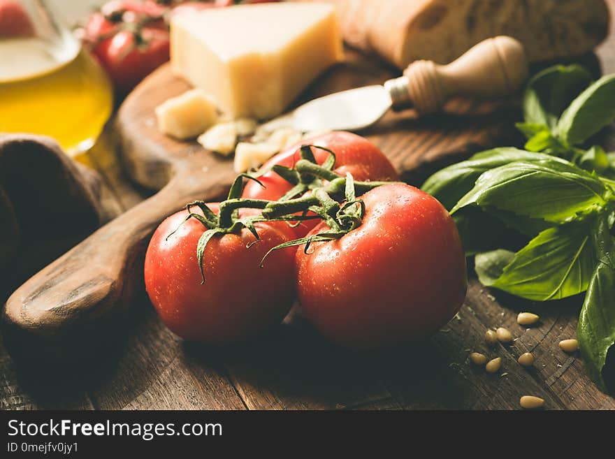 Tomatoes on vine, parmesan cheese, olive oil, basil and ciabatta bread. Italian cuisine food ingredients. Closeup view, toned image. Tomatoes on vine, parmesan cheese, olive oil, basil and ciabatta bread. Italian cuisine food ingredients. Closeup view, toned image