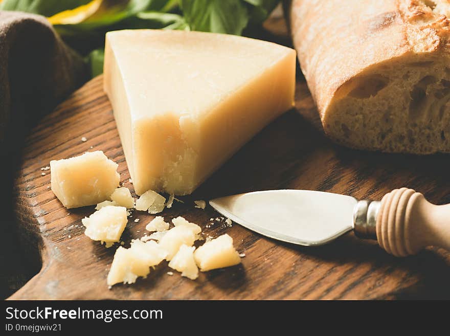 Parmesan cheese and cheese knife on wooden board