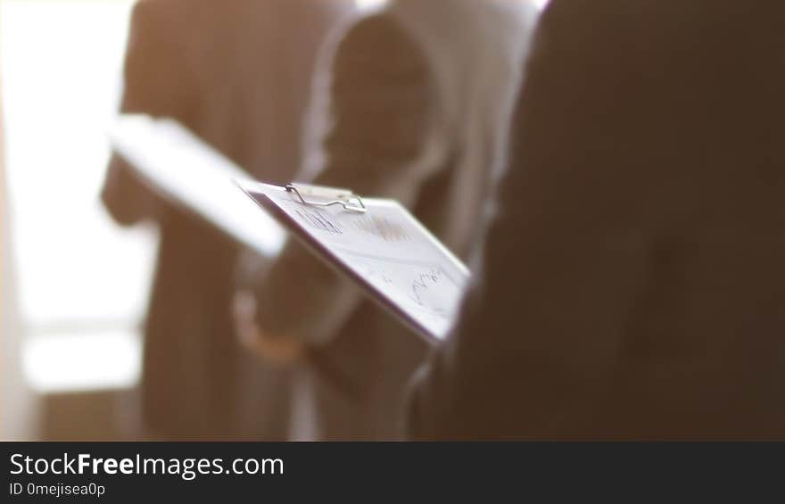 Close up.businessman with a clipboard on the background of colleagues