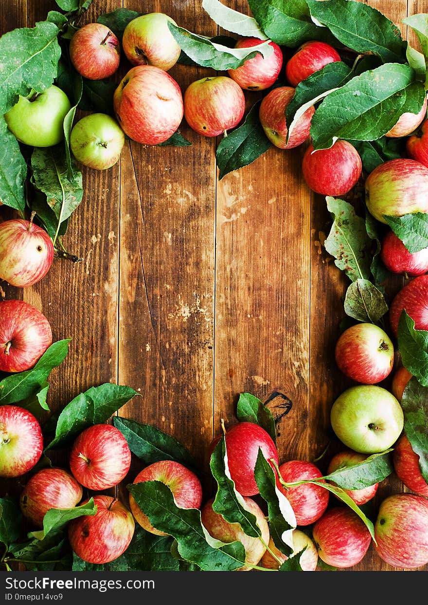 Ripe red apples with leaves on wooden background. Shallow dof. Ripe red apples with leaves on wooden background. Shallow dof.