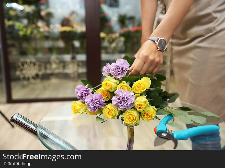 Female florist making beautiful bouquet in flower shop, closeup